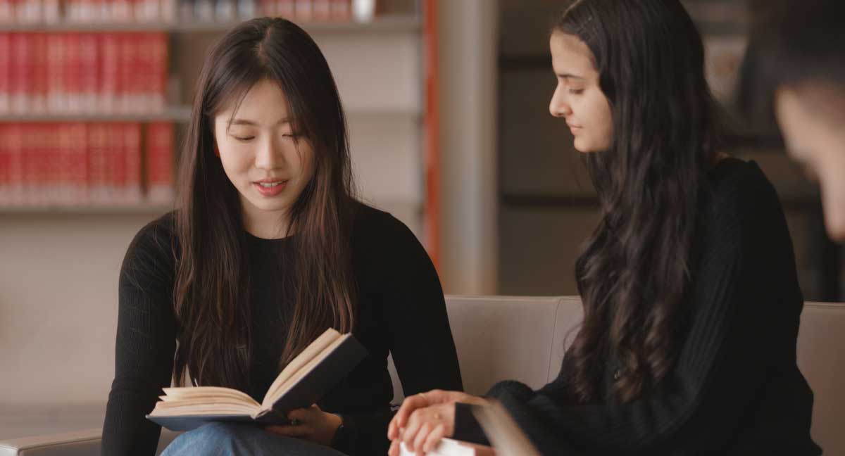 Two students looking at a book