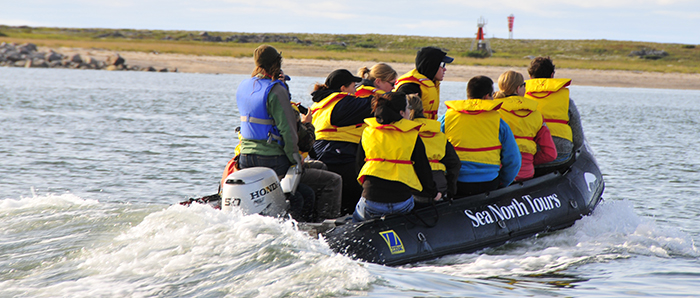 Students travelling in a Zodiac on the Churchill River