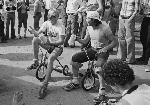 Black and white image of tricycle race participants.