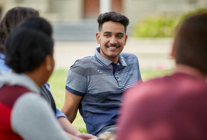 Student sits on Wesley Hall lawn