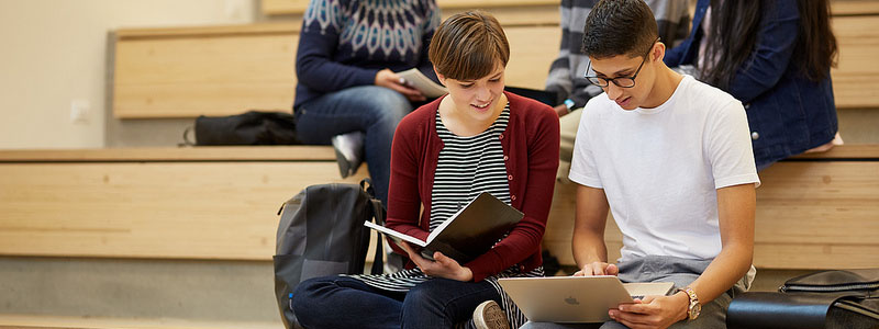 Students pointing and reading textbook