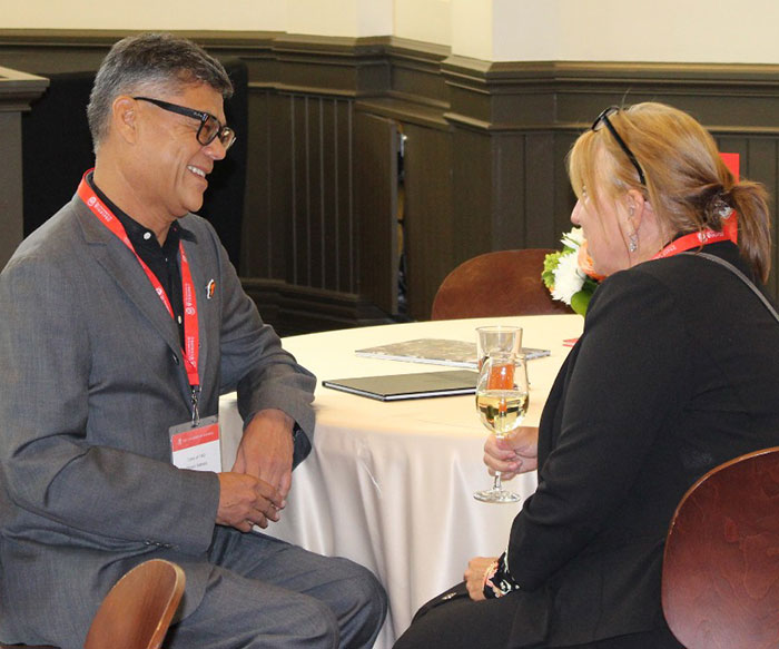 Two alumni sitting at an event talking