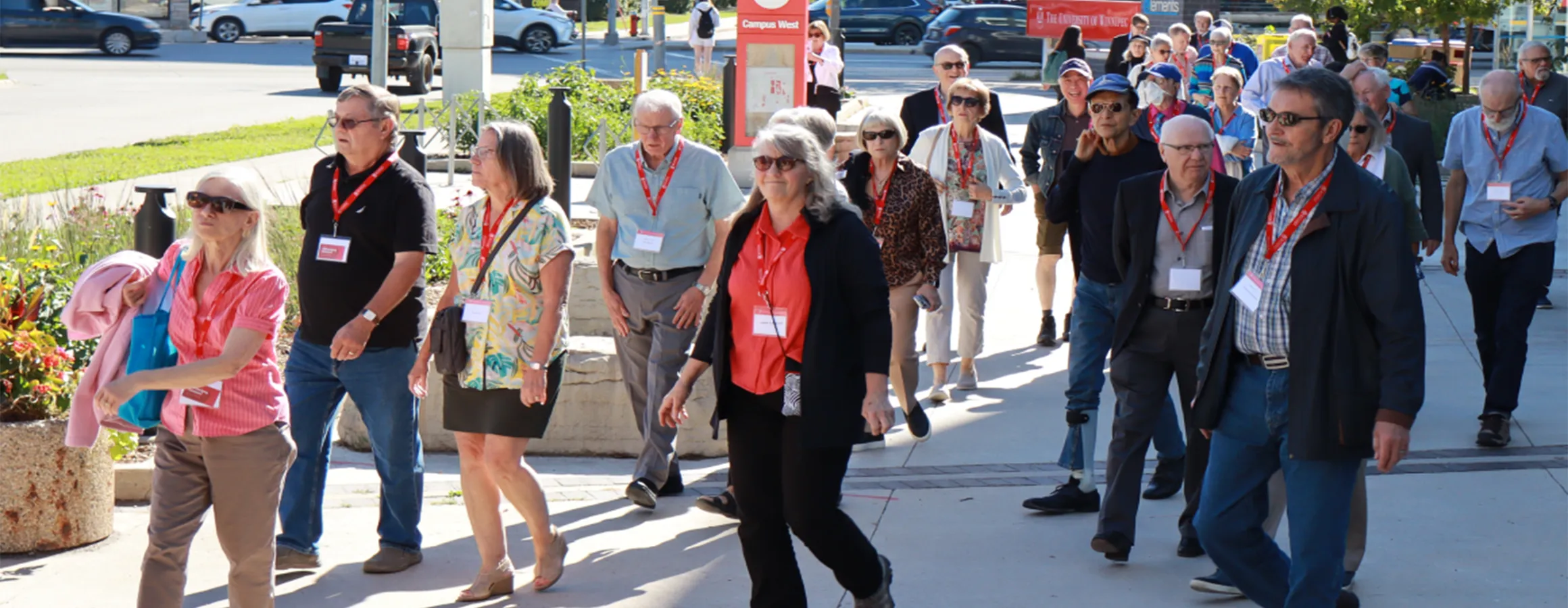 Group of people all wearing nametags walking outside on a tour.