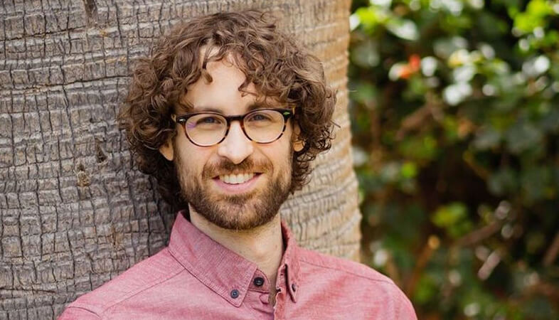 Head shot of jordan Sloshower standing in front of a tree