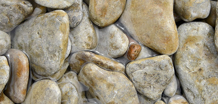 rounded stones along a shoreline with water in between them