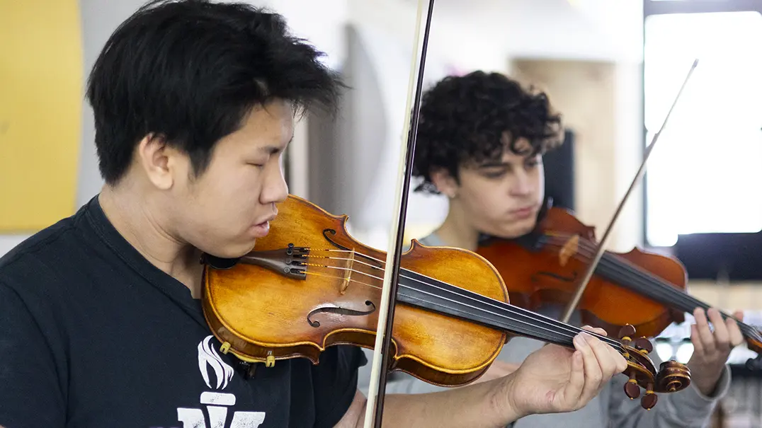 Two students playing violin