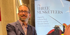 photo of Christopher Brauer against a sign for the production