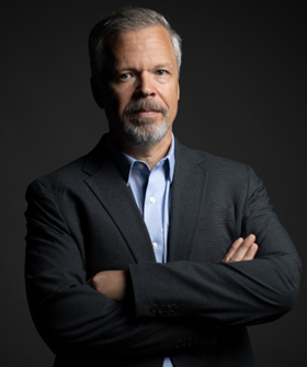 Dr. Derrick Nault standing against a dark background