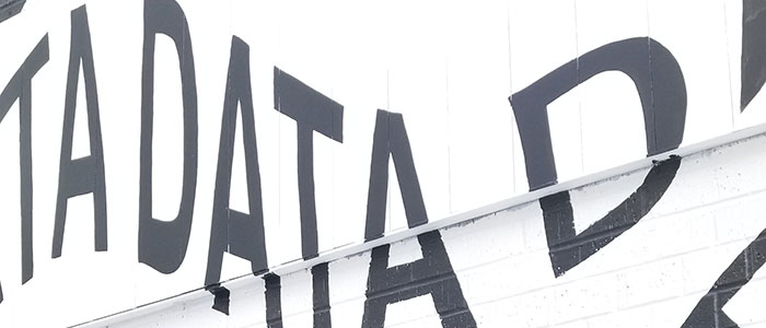 The word "Data" in black text on a white brick wall