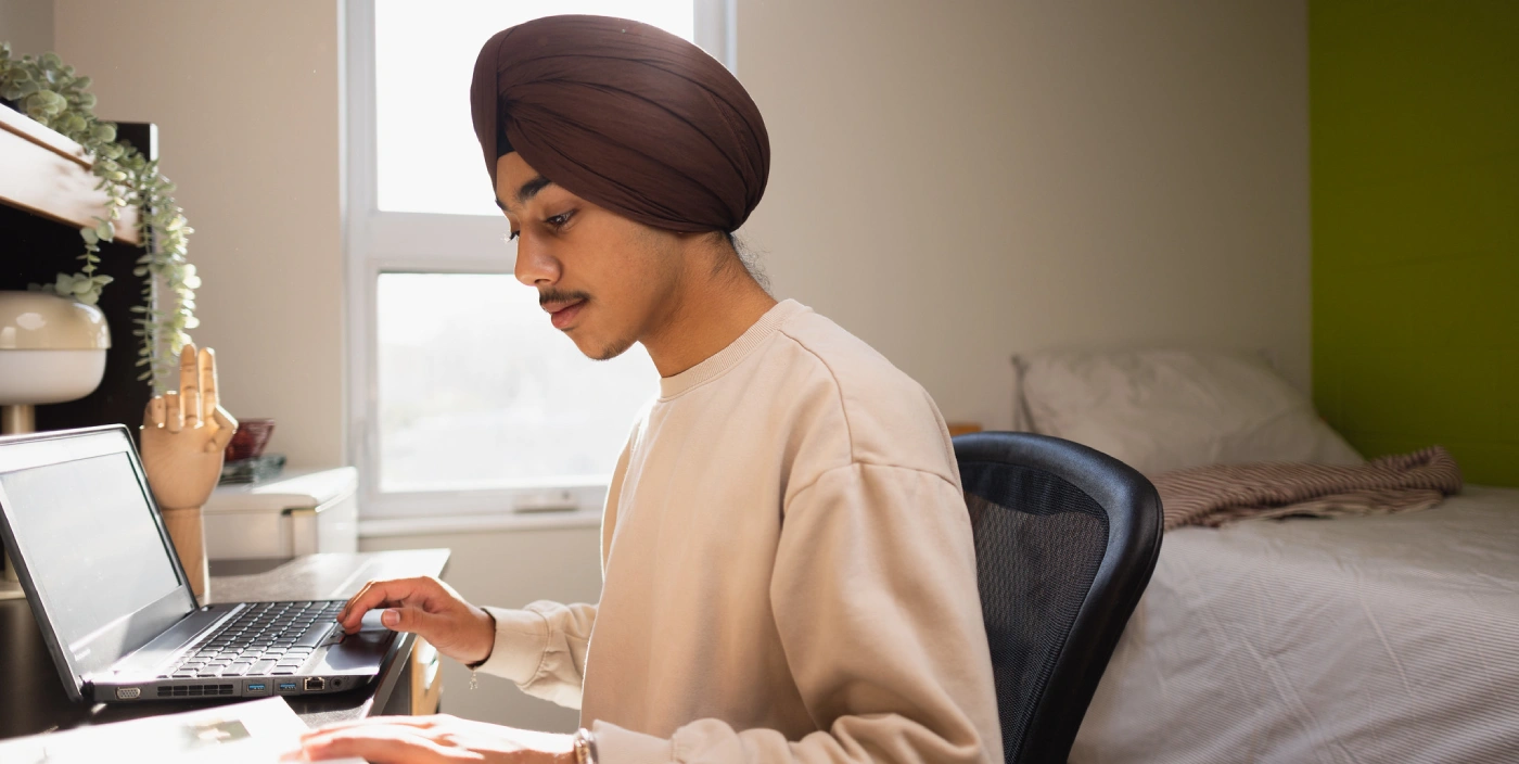 A student work at a desk in a McFeetor's Hall room