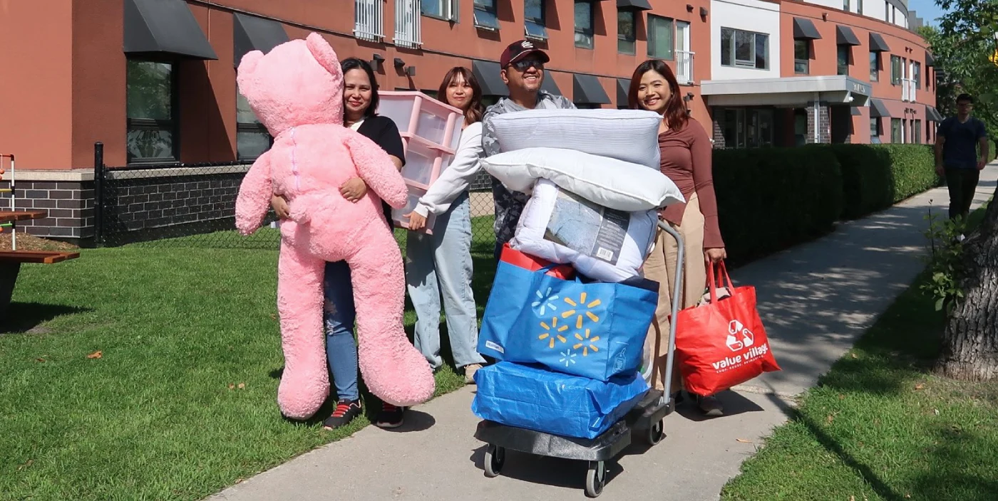 A student and family members with luggage at McFeetors Hall