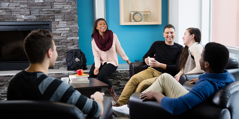 Students sitting on couches talking in the McFeetors Hall Lobby