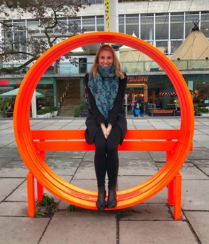 Dr. Victoria Austen, sitting in orange circular sculpture