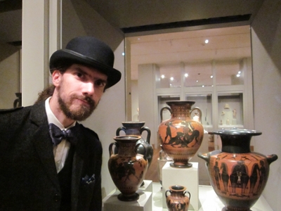 Dr. Warren Huard, posing next to black-figure pottery featuring the figure of Herakles