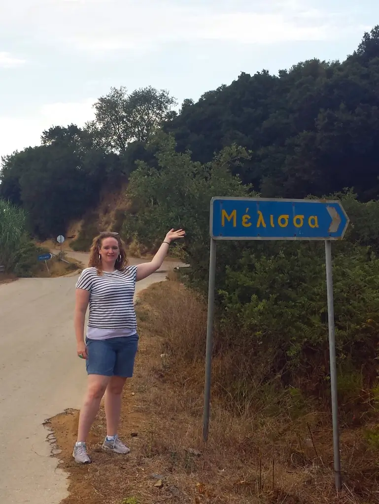 Dr. Melissa Funke showcasing the sign for the village of “Melissa” in Greece