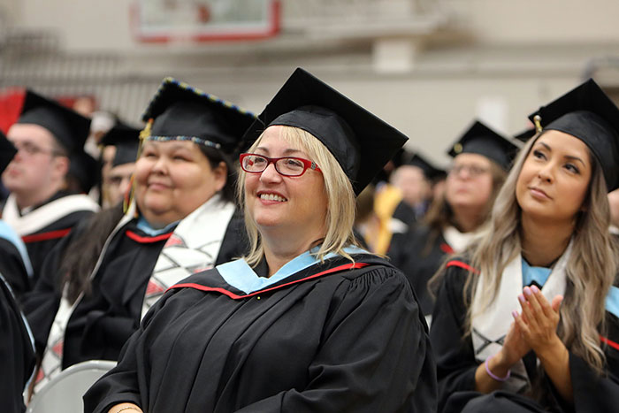 Students in regalia smiling at convocation