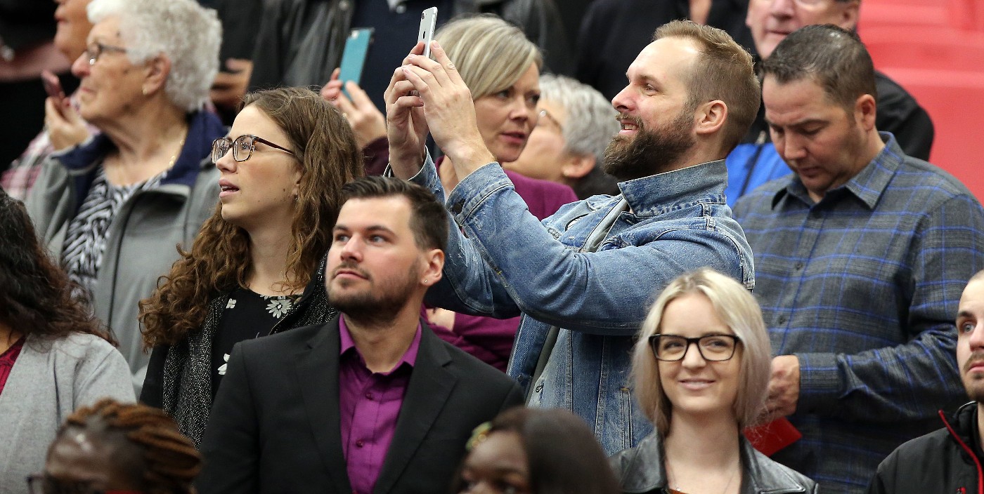 Family and friends in seats, one person standing to take a photo