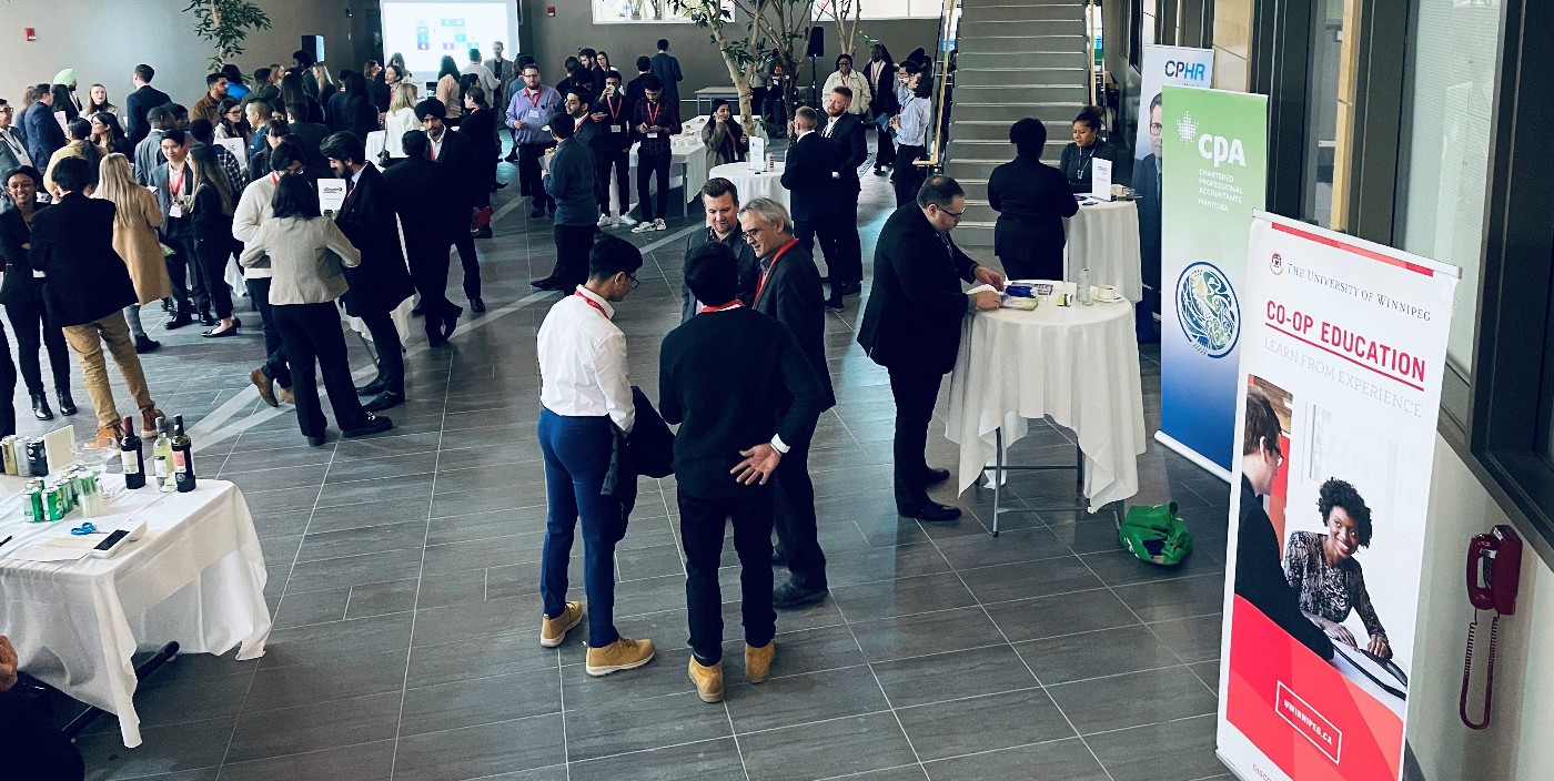 People gather in a large atrium, and a stand-up banner reads Co-Op Education