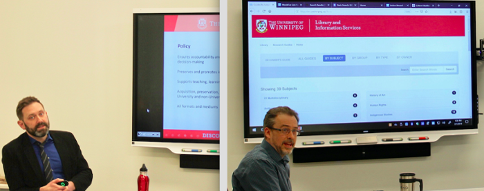 People having a discussion at a table front of computer screen