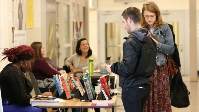 students looking at books ©UWinnipeg