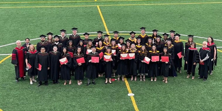 Overhead picture of graduates standing on indoor field 