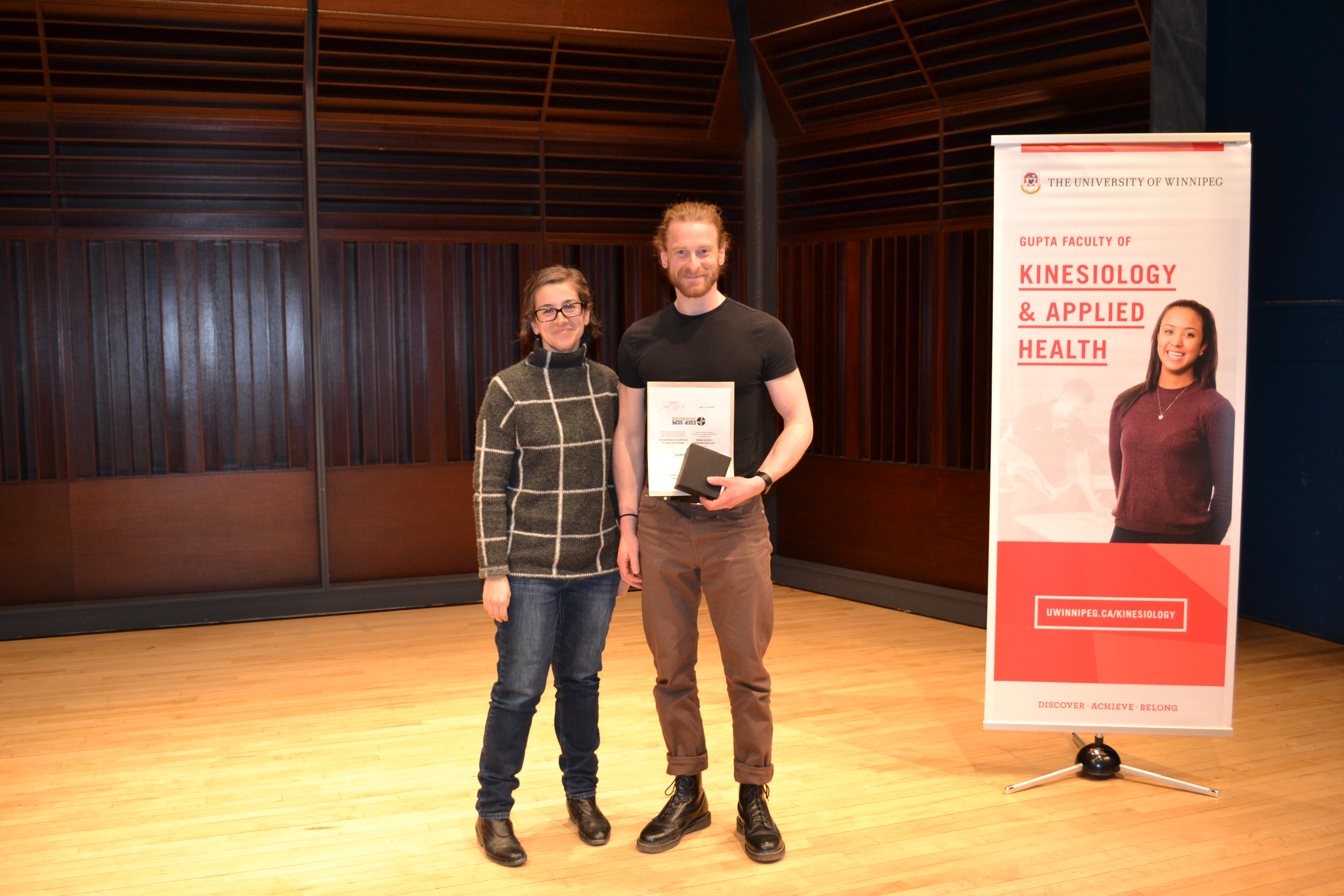 Dr. Danielle Defries presenting an award to Justin Rivard