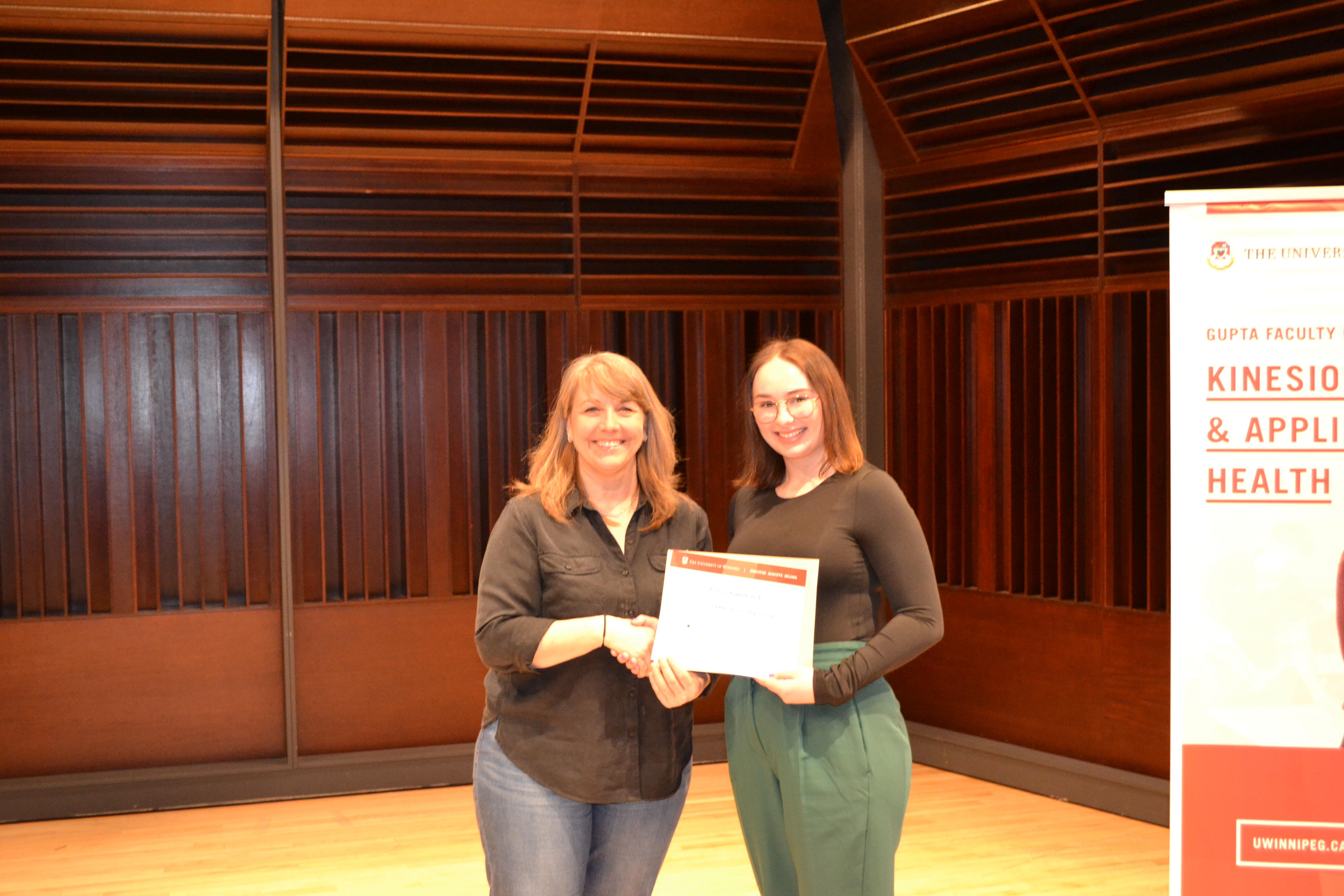 Faculty member Andrea Smith presenting an award to Kiley Gmiterek