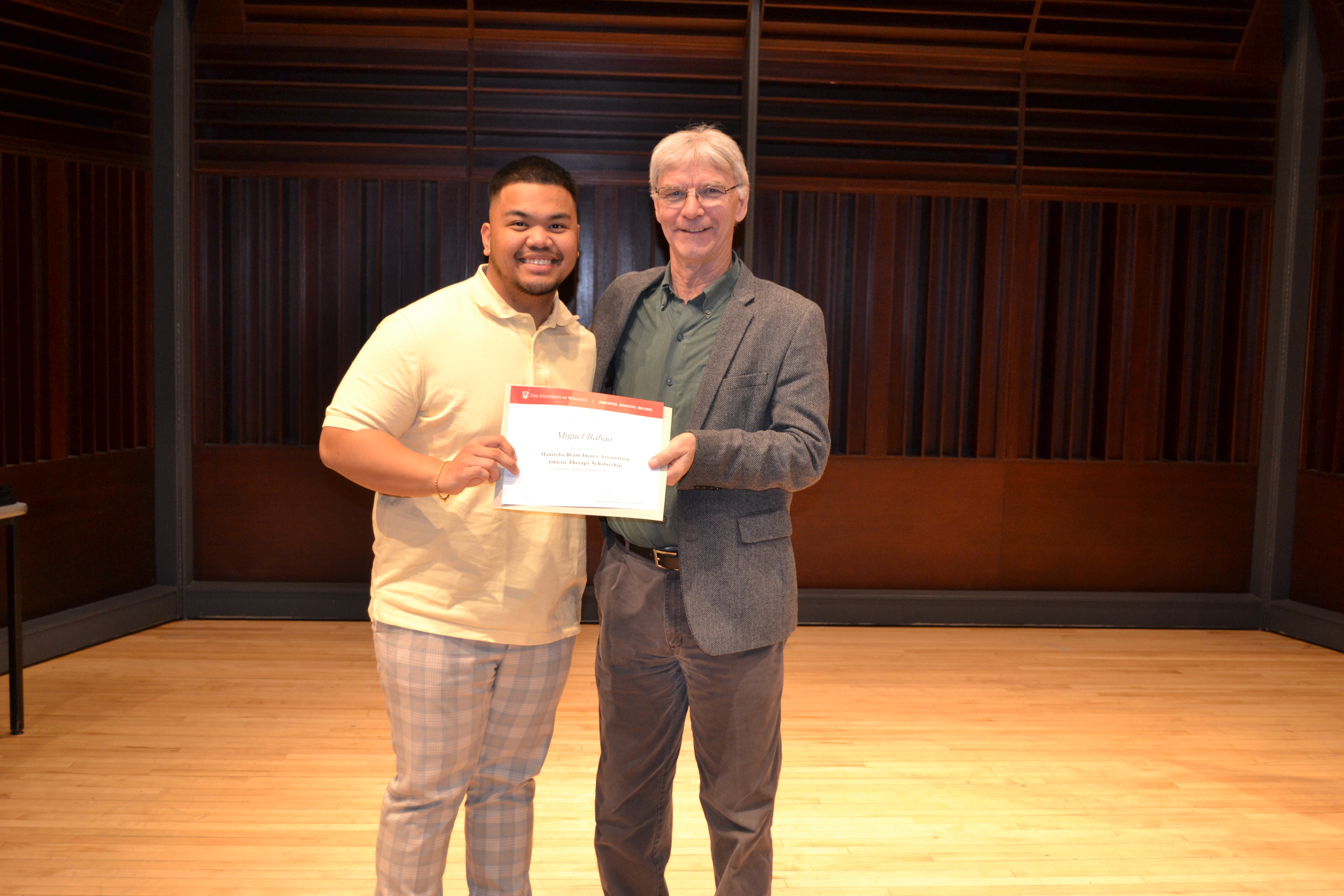 Director of the Athletic Therapy Program, Dr. Glen Bergeron presenting an award to Miguel Babao