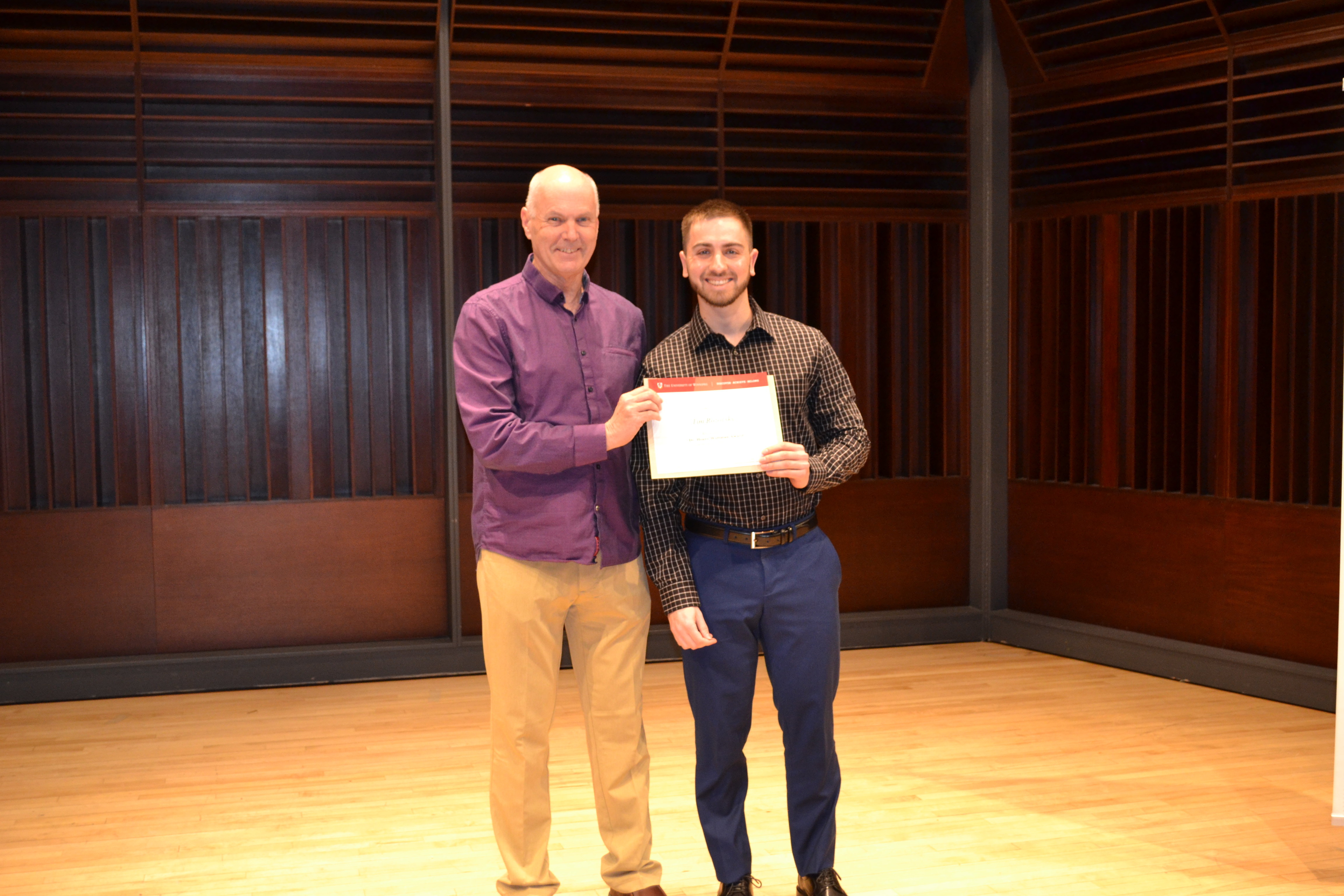 Dr. David Telles-Langdon presenting an award to Tim Rozovsky