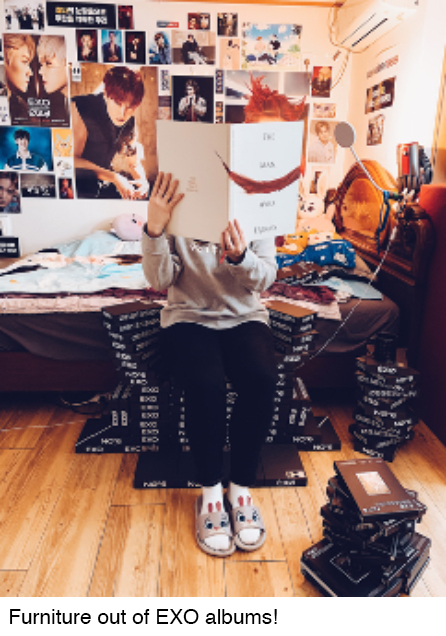 The author is sitting on a chair made of k-pop albums.