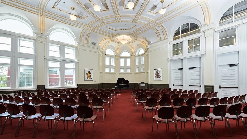 A large room set up with chairs, image take from back of the room
