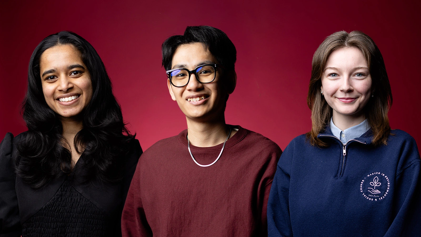 Three students standing in front of a maroon background