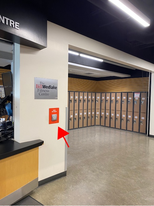 Arrow pointing to access point on wall with lockers in the background.