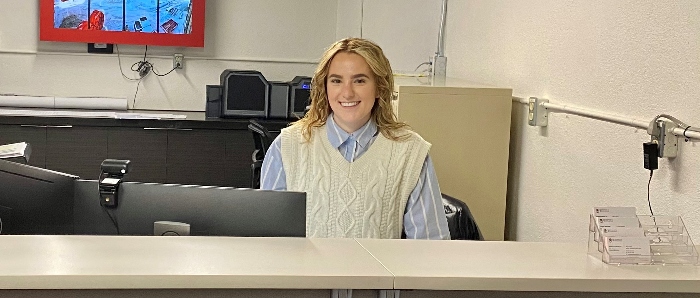 Staff member standing behind desk.