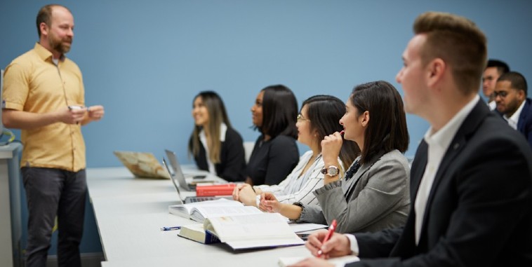 A professor stands at the front of a room of students