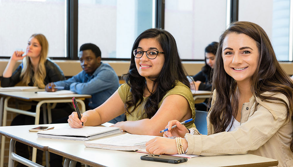 Students in a classroom looking towards camera