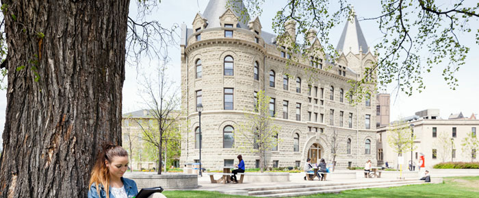 UWinnipeg Student on front lawn of Wesley Hall