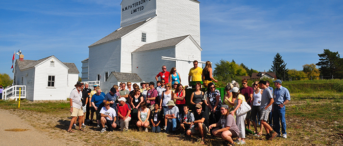 Conference delegates in front of grain elevator, Inglis, Manitoba