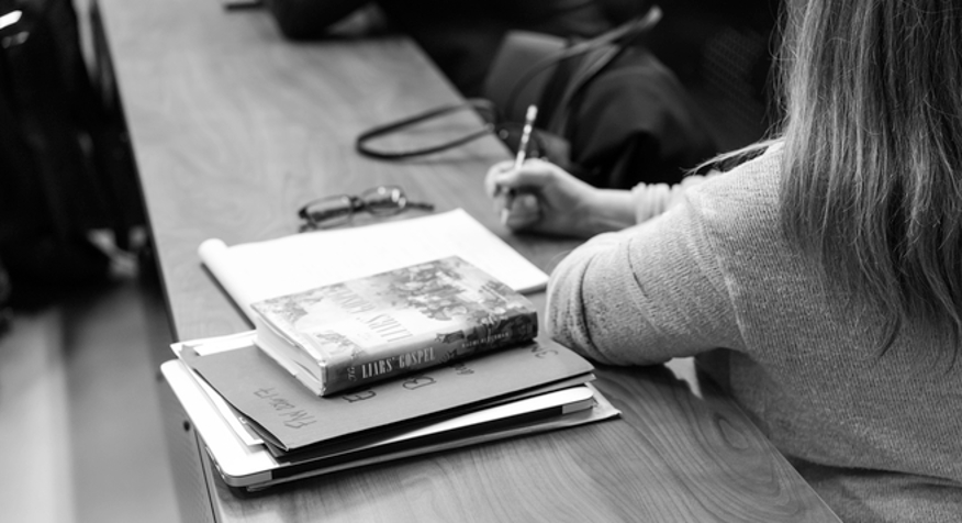 Image of a student seated at a table with textbooks.