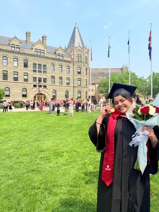 Abhijot Kaur Chohan at convocation outside, holding a medal and a bouquet of roses