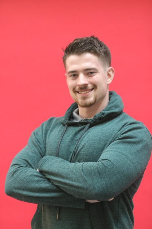 ISSP scholar Manuel Candaele stands smiling with his arms crossed