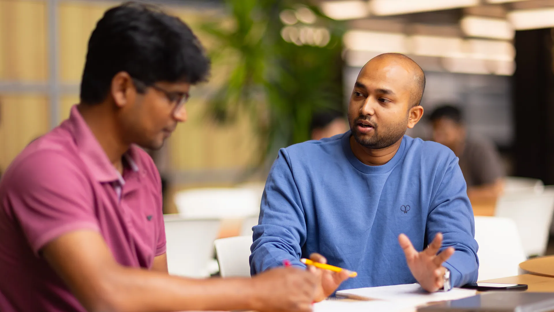 Two students talking at a desk