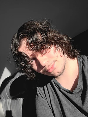 Head shot of Brandon - he has curly brown hair and a mustach