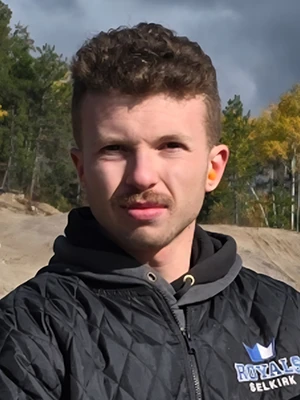A headshot of Kadyn with short brown hair and a mustache