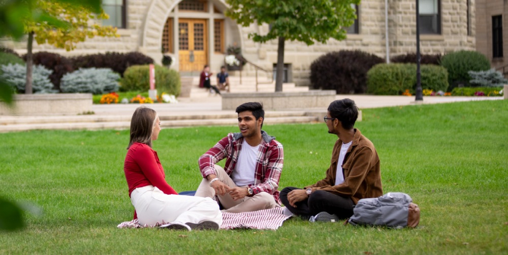 Students sit on the front lawn of Wesley Hall