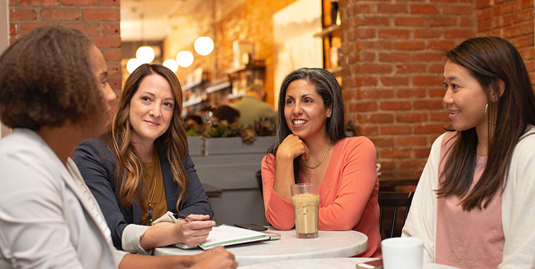 Four women talking at a table