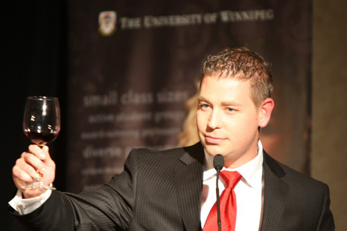 Man at podium making a toast with wine glass