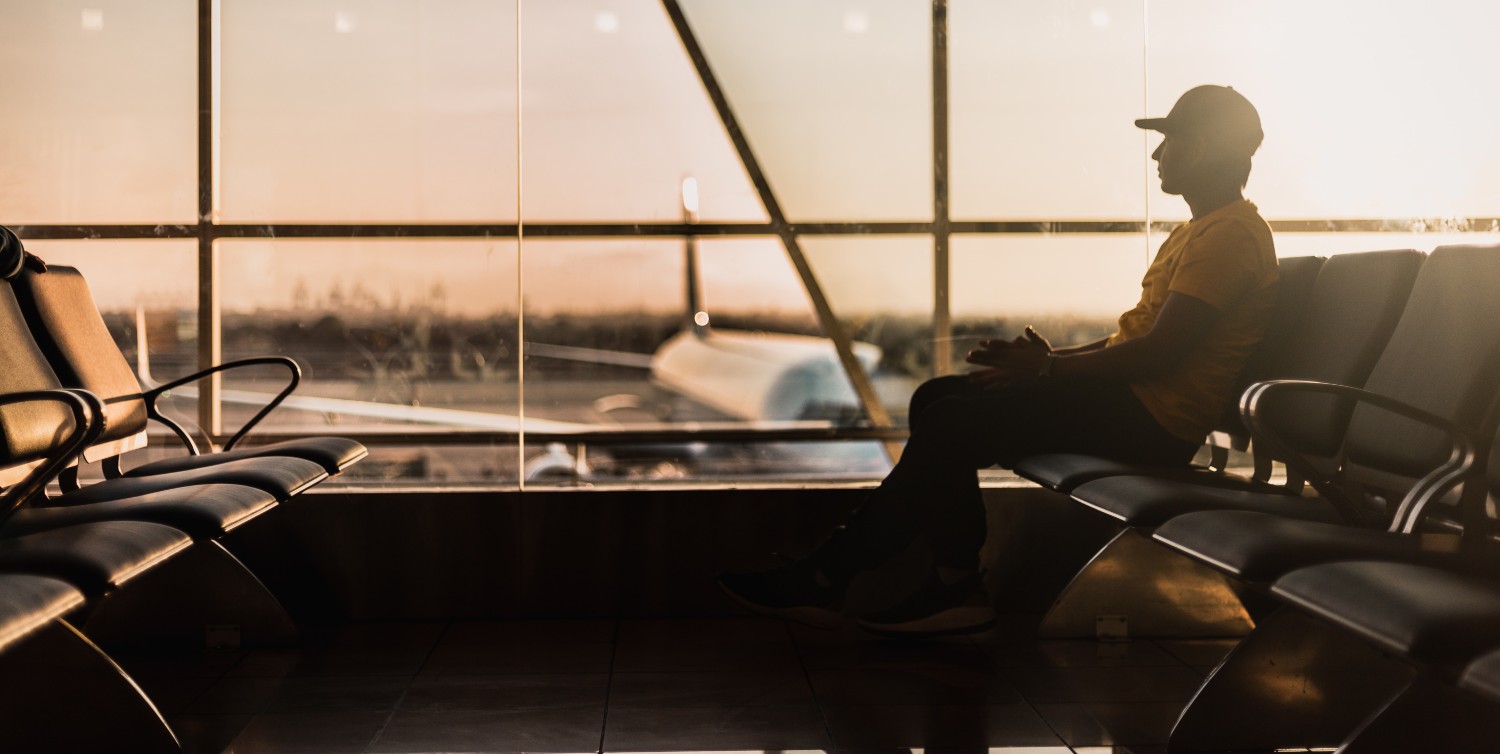 Person sitting in an airport during sunset