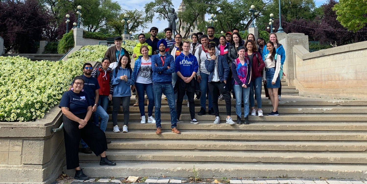 A collection of students standing on steps smiling