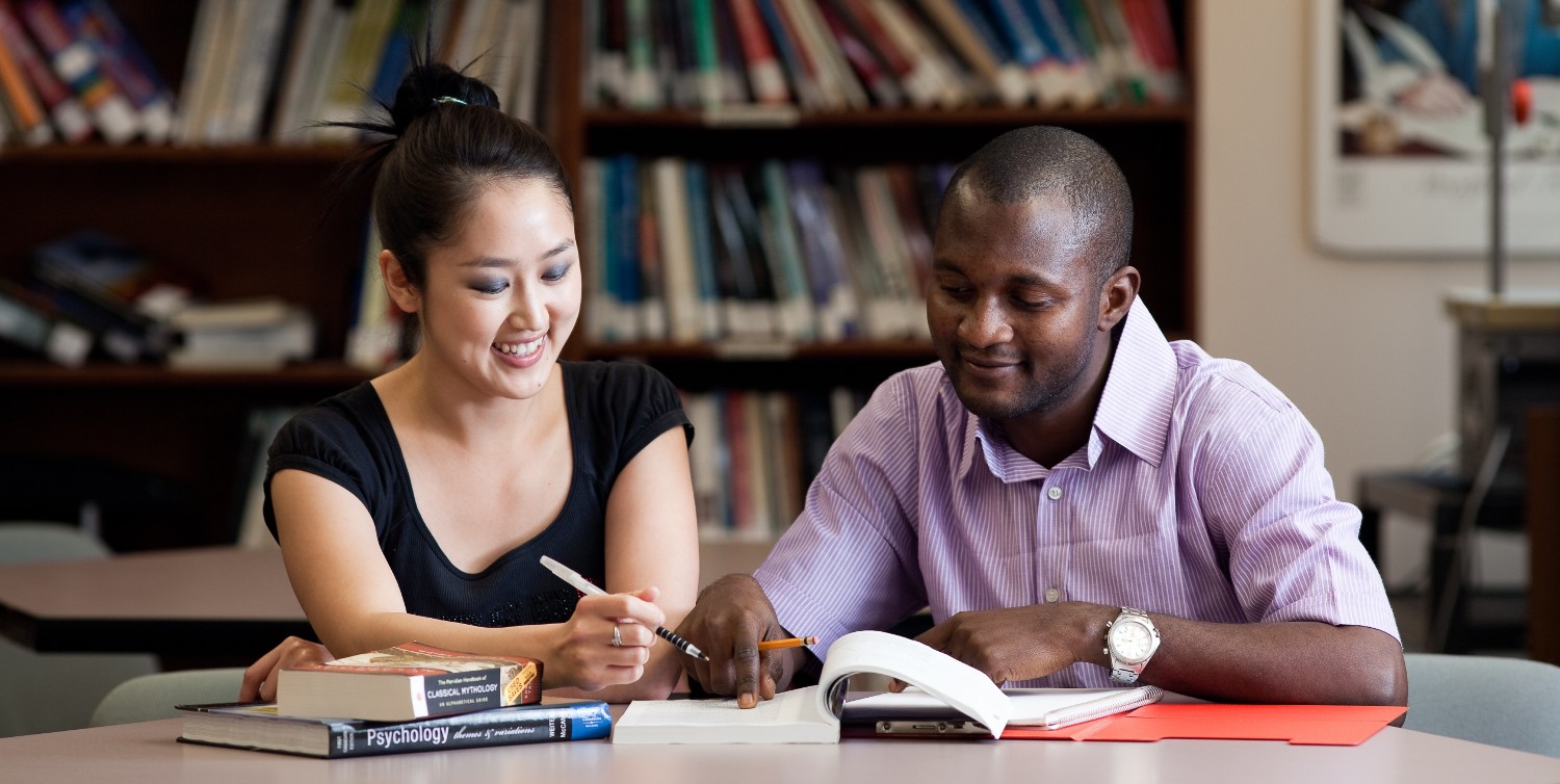 A student and a tutor working at a desk